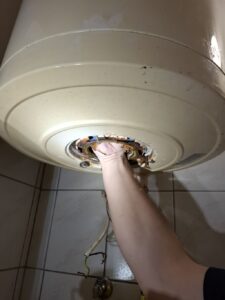 villanybojler vízkőtelenítés szakember által karbantartás közben